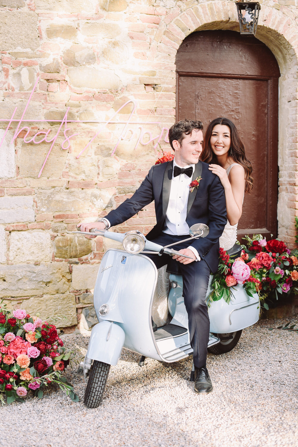 bride and groom getting ready to buzz away on their baby blue Vespa