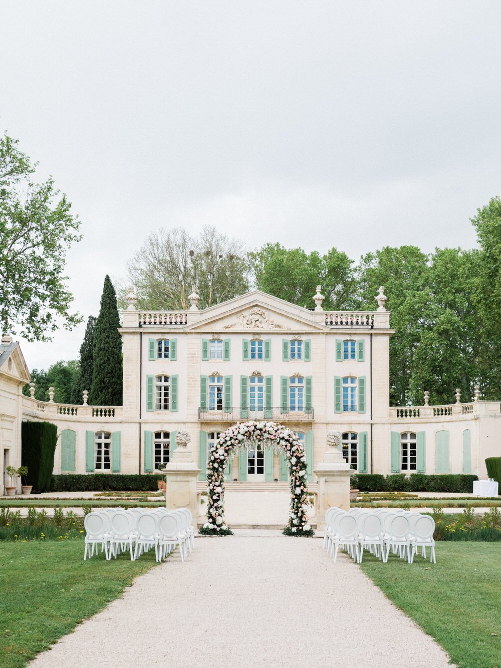 french chateau wedding ceremony with a floral arch