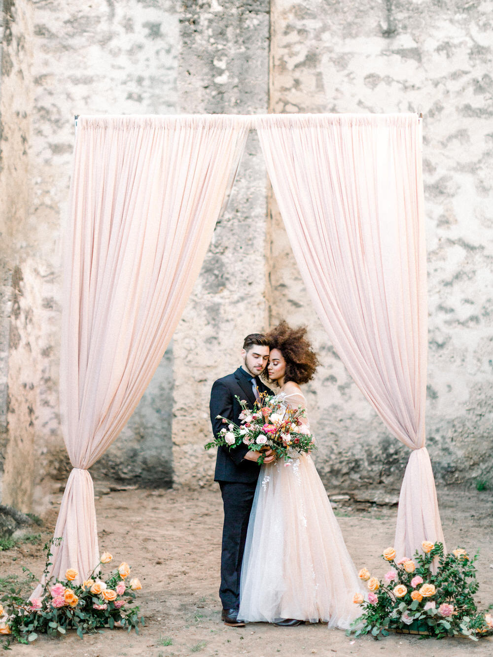 soft blush pink draping at wedding ceremony with bride and groom