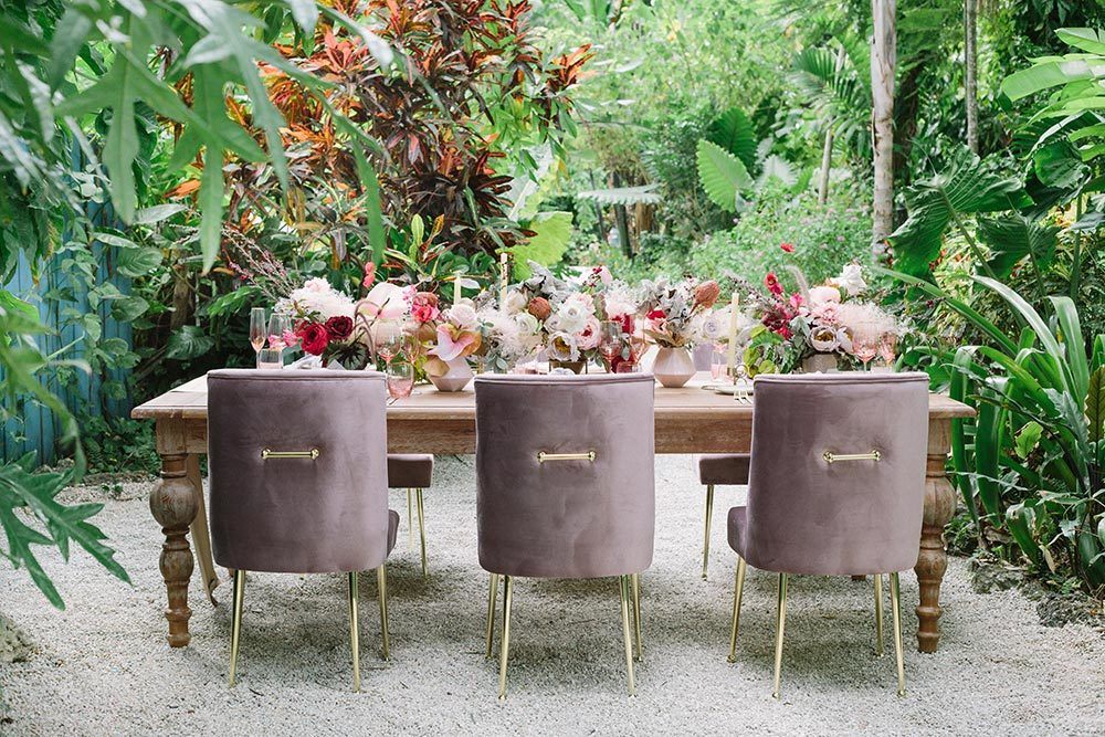 farmhouse wedding table with pink velvet chairs and silk flowers