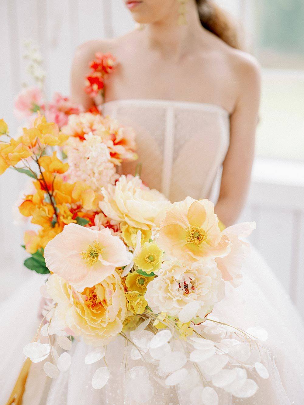 citrus bridal bouquet with modern strapless wedding dress with sequins and corset bodice