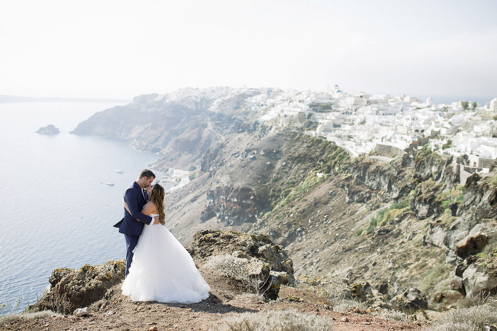 ruffled wedding dress and navy groom suit Santorini couple portraits